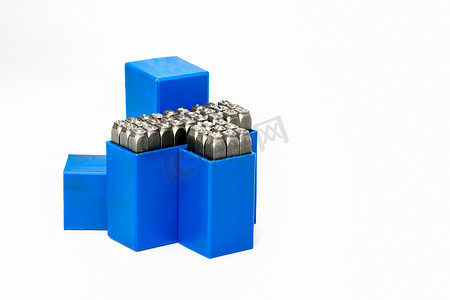 一组金属印章字母和数字打孔在蓝色塑料盒中隔离在白色背景与复制空间
