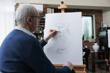 高级男画家在画布上绘制花瓶模型