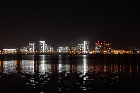 模糊的照片，夜晚的城市灯光反射在水中，城市景观