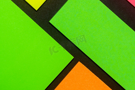 黑纸上有绿色、黄色、橙色和玫瑰色彩色办公室贴纸。