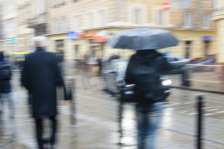 雨中街道摄影照片_人们在雨中走在街上。