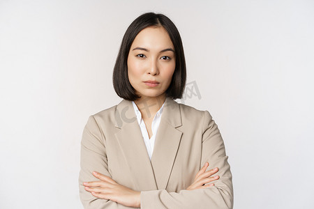 女脸手摄影照片_自信的女企业家，站在权力姿势的亚洲女商人，职业商人，胸前交叉双臂，站在白色背景上