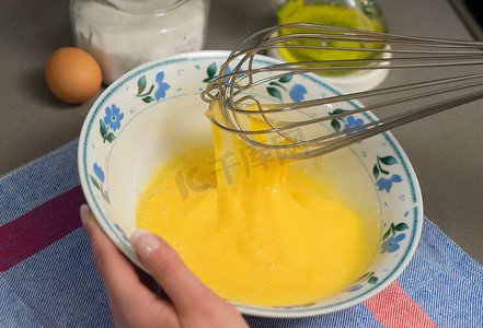 用打蛋器在白碗里打鸡蛋
