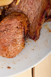 烤肉片摄影照片_鹿肉、野味肉片和野生蘑菇