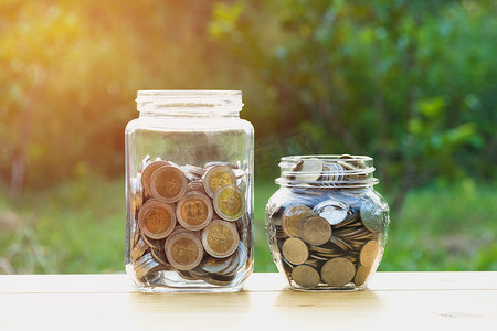 罐子里的硬币与钱堆在一起，不断增加资金、概念金融业务和储蓄投资。