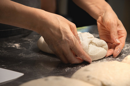 厨师面团摄影照片_特写面包师做面包，女手，揉面团，烹饪