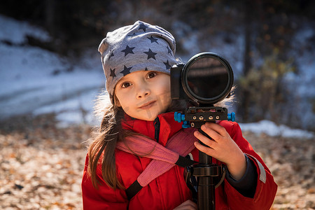 户外戴着星帽相机的快乐小女孩的肖像