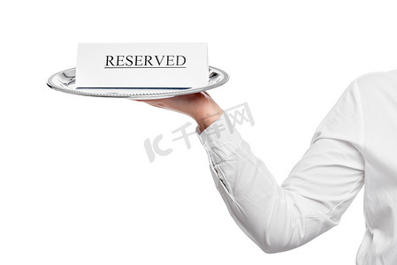 餐饮预订摄影照片_餐厅的餐桌预订广告出现在服务员的托盘上