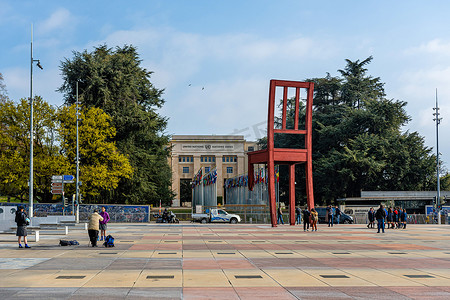 建筑学摄影照片_联合国宫附近的断椅纪念碑与游客