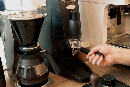 咖啡师研磨咖啡的特写镜头，准备冲泡浓咖啡