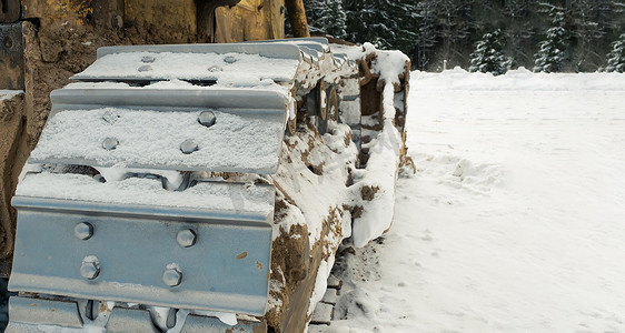冬天，推土机拖拉机的金属履带清除了道路上的积雪。