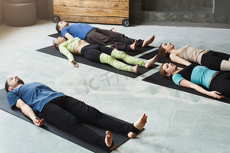 瑜伽课上的一群人，练习后躺在地板上