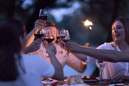 朋友们在户外野餐法国晚宴时举杯敬酒
