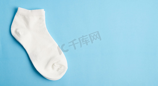 衣服图案摄影照片_蓝色背景上的白色袜子和文本空间。