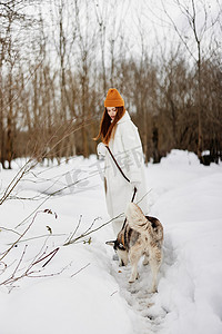 雪地里的年轻女子在户外与狗玩耍友谊寒假