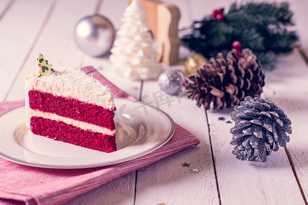 木质背景和十二月红色织物板上的圣诞蛋糕