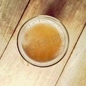 果味啤酒摄影照片_木吧桌上的一杯啤酒