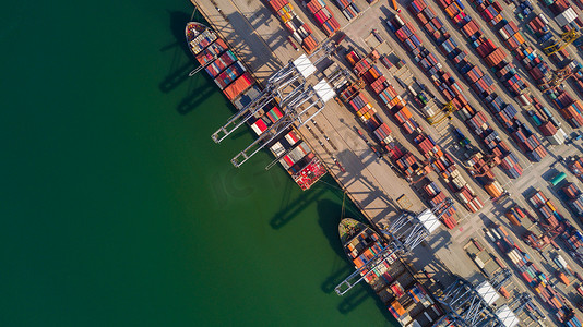 港口鸟瞰集装箱船货运，全球商业物流进出口货运在全球范围内运输，集装箱船货物货运船国际。
