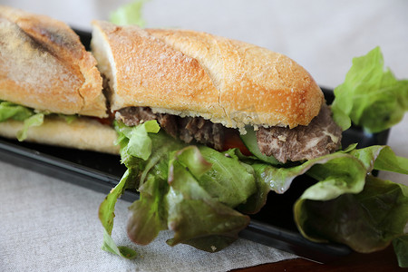牛肉三明治摄影照片_木材背景上的牛肉三明治