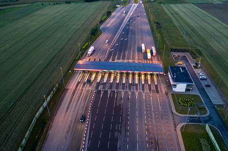 多车道高速公路和收费站的汽车交通运输，夜间无人机空中顶视图。