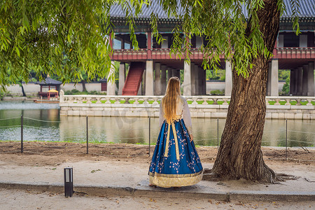 韩服图腾摄影照片_穿着韩服的年轻白人女游客在韩国宫殿。