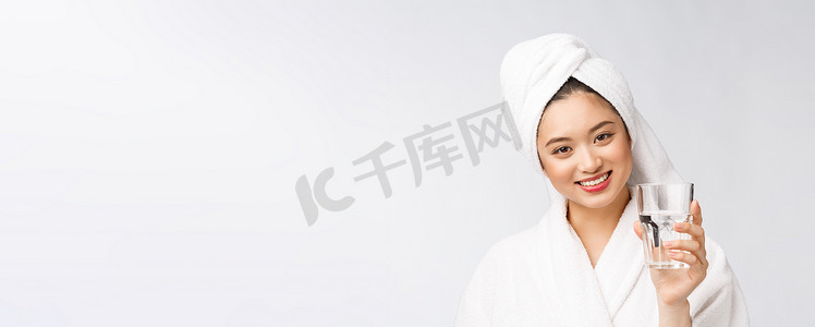 健康年轻漂亮的女人喝水，美丽的脸自然妆，孤立在白色背景。