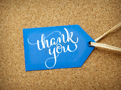 谢谢文字摄影照片_软木背景和文字上的蓝色贴纸销售谢谢。