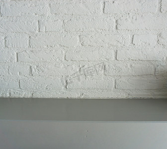 空表面灰色木桌面，白色砖墙背景