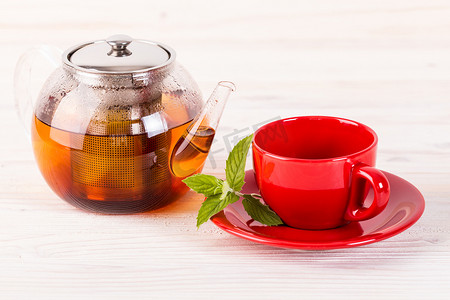 小茶壶摄影照片_茶壶和红色杯子在木桌上
