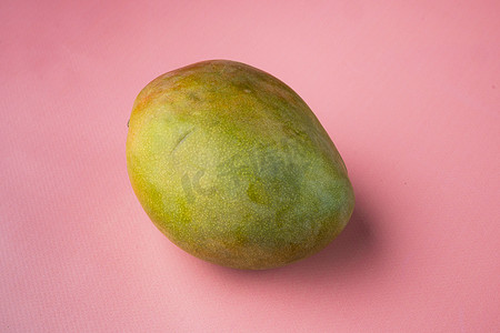 成熟的芒果果实，在粉红色质感的夏季背景中，带有文本复制空间