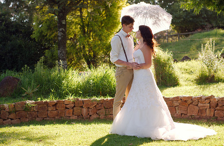 新娘和新郎在带遮阳伞的花园婚礼中