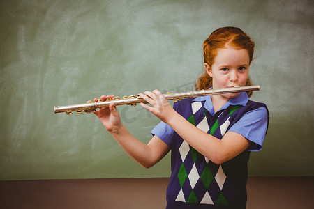 学习的小女孩摄影照片_可爱的小女孩在教室里吹长笛