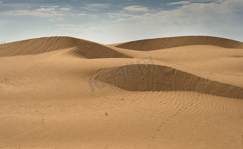 天空沙漠背景摄影照片_美丽的密集黄沙结构，沙漠沙丘。