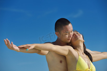 快乐的年轻夫妇在海滩上享受夏天