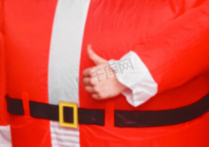 穿着新年节日圣诞老人服装的家伙的手竖起大拇指向班级展示。