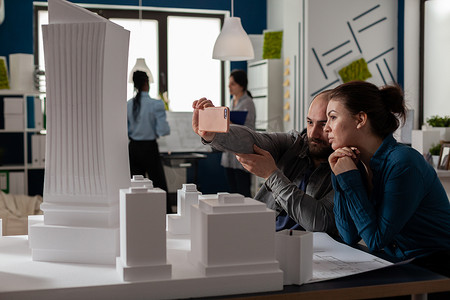 两位建筑师同事在视频电话会议中使用智能手机的团队