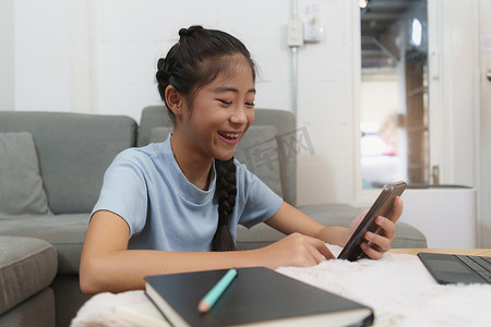 上学的摄影照片_在家上学的亚洲小女孩学生学习在线课程。
