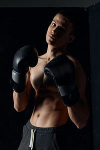 黑色背景肖像裁剪视图中戴着拳击手套的运动员