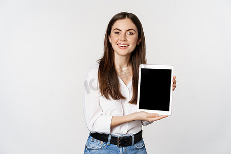 展示平板电脑屏幕、展示公司网站、站在白色背景上的企业女性肖像