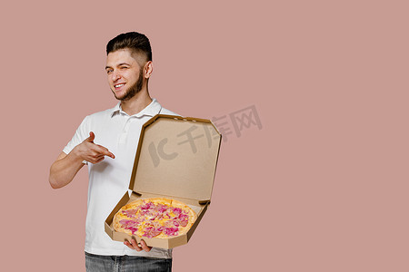 披萨广告摄影照片_英俊的年轻快递员有披萨点。