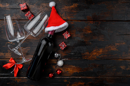 葡萄酒酒装饰摄影照片_带有新年树装饰的圣诞酒，在旧的深色木桌背景上，顶视图平躺，带有文本复制空间