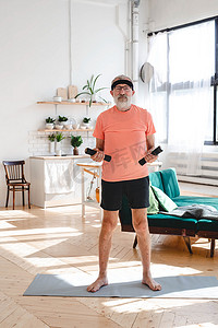 哑铃摄影照片_老人用哑铃在家做健身运动 — 老年人与健康概念