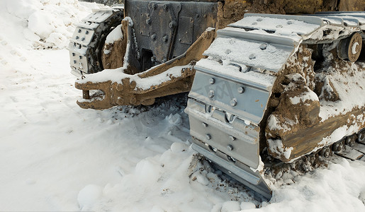 冬天，推土机拖拉机的金属履带清除了道路上的积雪。