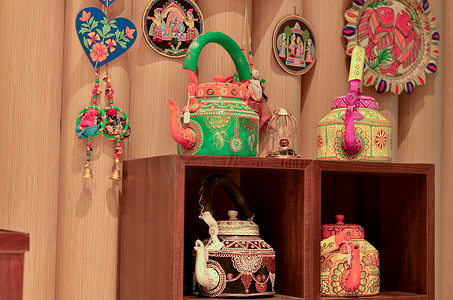 印度新德里迪利哈特的一家零售店里陈列着色彩缤纷的装饰性传统印度水壶、捕梦网和风铃