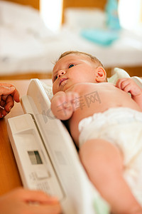 加权摄影照片_体重秤上的婴儿