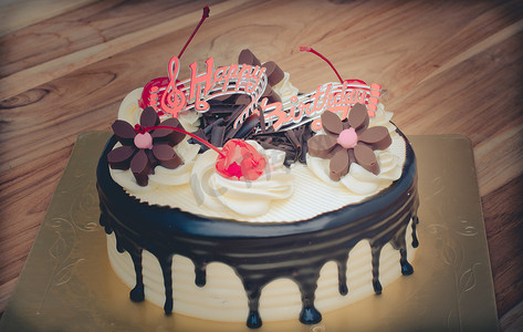 生日蛋糕，香草巧克力樱桃被分成几块放在木桌上。