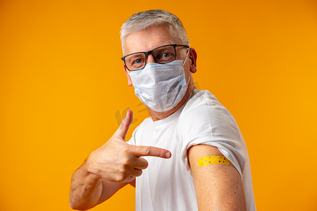 黄色背景的老人接种了冠状病毒疫苗