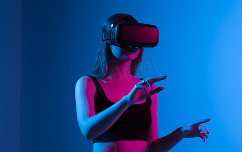 戴着 VR 耳机并与虚拟环境或应用程序交互的女性视频游戏设计师的肖像。