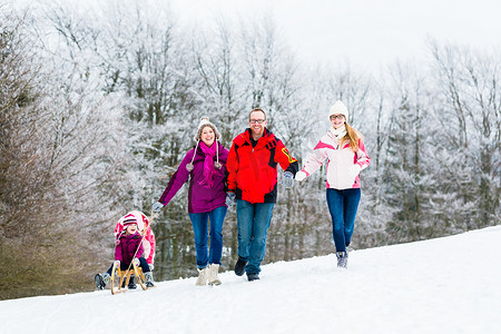 有孩子的家庭在雪地里冬天散步