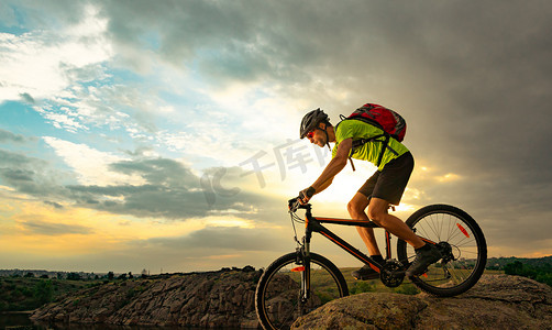 日落时分，骑自行车的人在岩石小道上骑自行车。